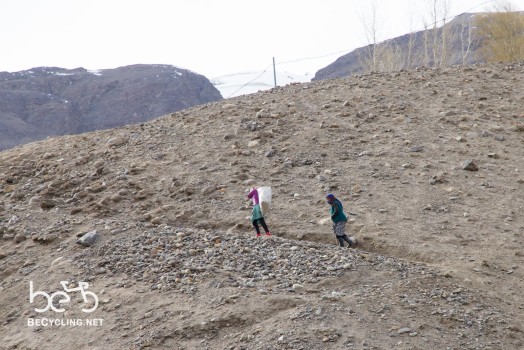 Women carrying stuff to their house on the hill
